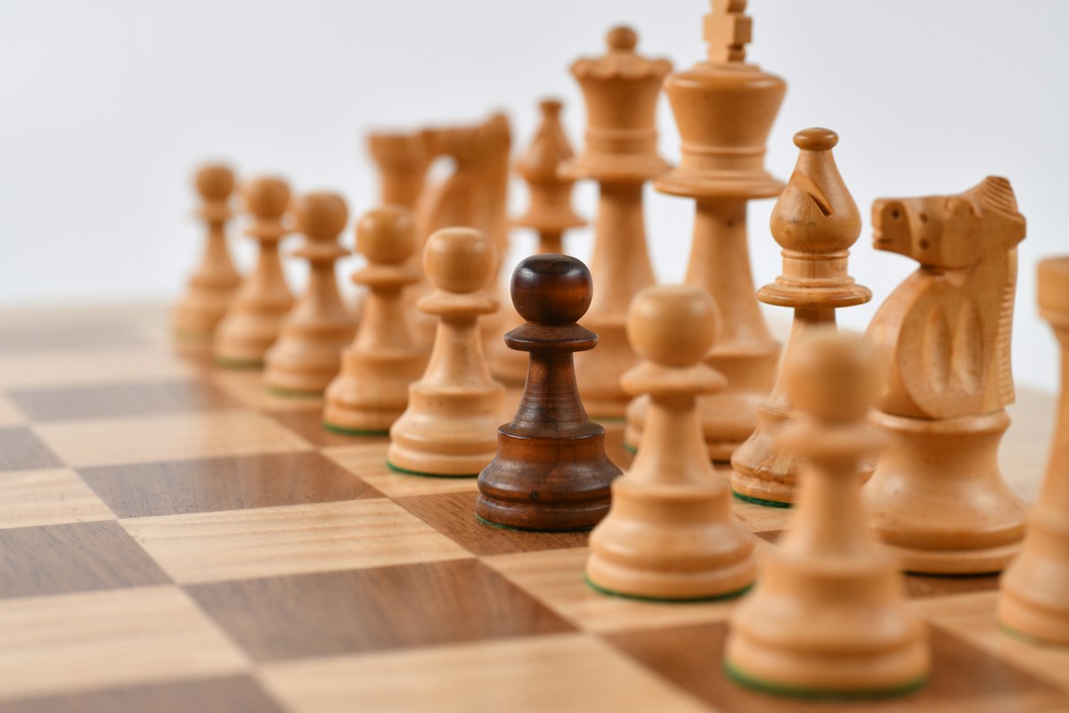 Wooden chess pieces set up on a chess board